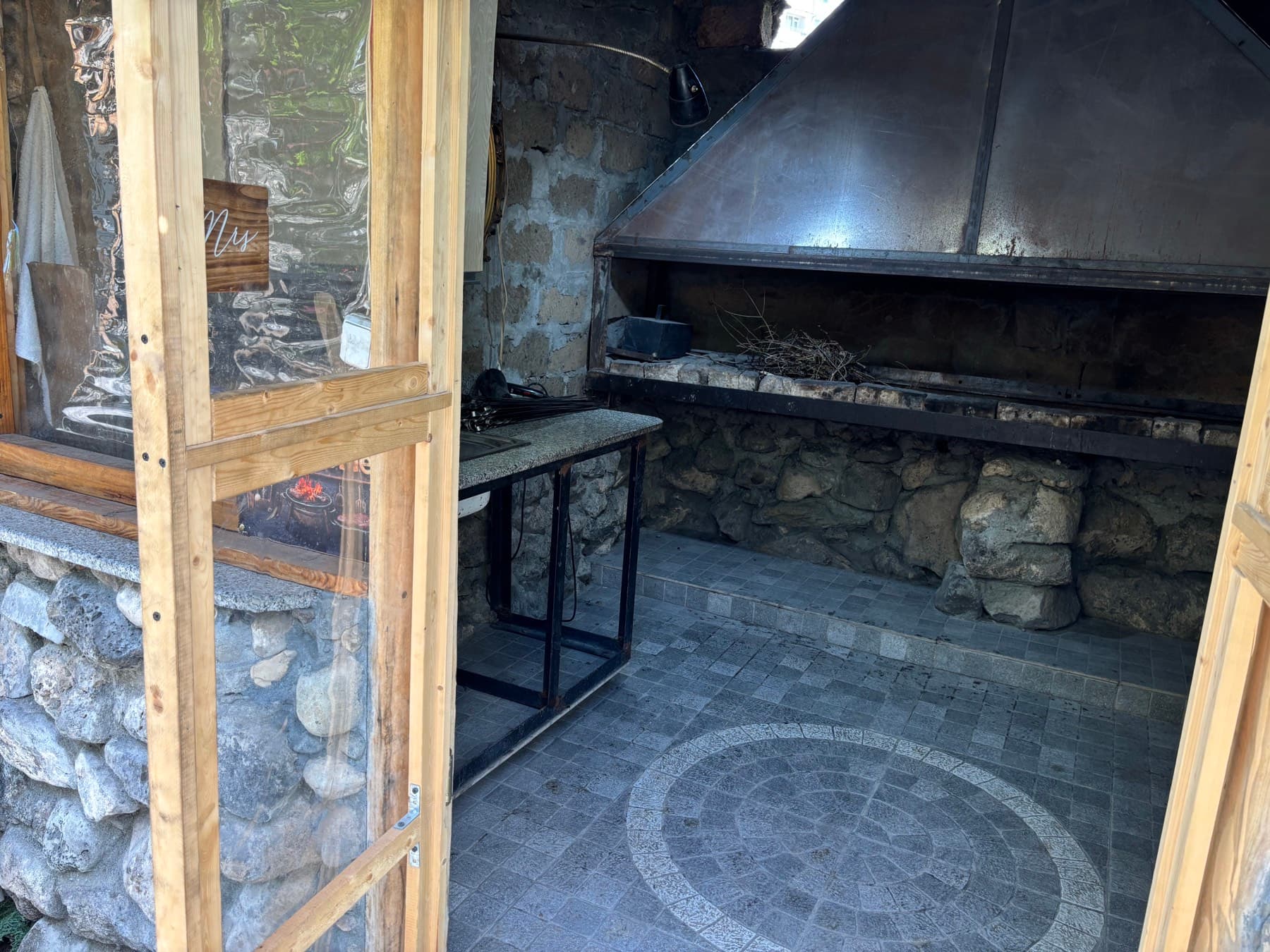 Villa Nors-ի ծածկած խորովածի տունը՝ քարե մանղալով, ամբողջ լայնքով օդաքարշով և պատրաստման սեղանով